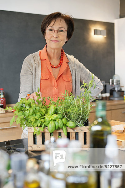 Frau steht in der Küche mit einer Bio-Pflanze