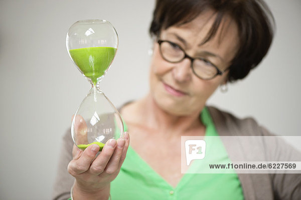 Woman looking at an hourglass