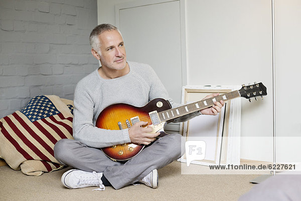 Man playing a guitar at home