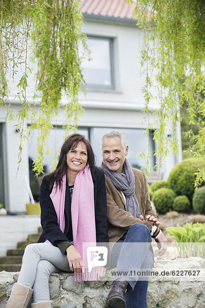 Romantic couple sitting in a garden and smiling