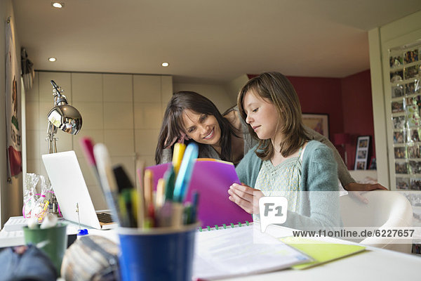 Girl studying with her mother at home