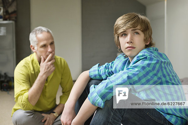 Mann sitzt mit seinem Sohn und sieht verärgert aus.
