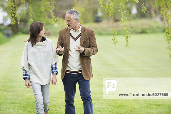 Man discussing with his daughter during walk in a park
