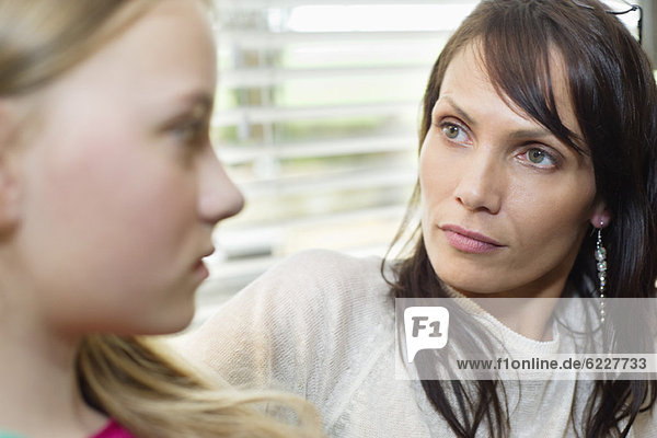Woman and daughter frowning to each other