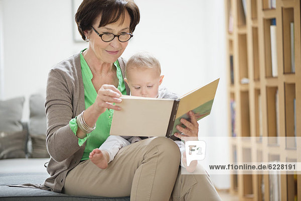 Frau mit ihrer Enkelin beim Lesen eines Bilderbuches