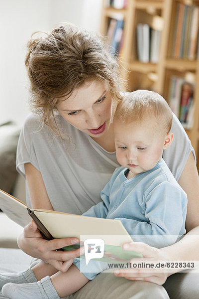 Woman teaching her daughter from a picture book
