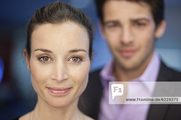 Porträt einer Geschäftsfrau lächelnd mit ihrem Kollegen im Hintergrund