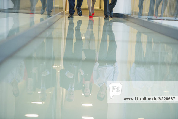Reflection of business executives on the glassy floor