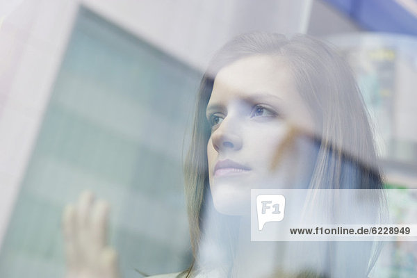 Businesswoman looking through the glass of a window