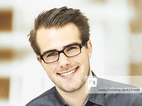 Smiling young businessman wearing glasses  portrait