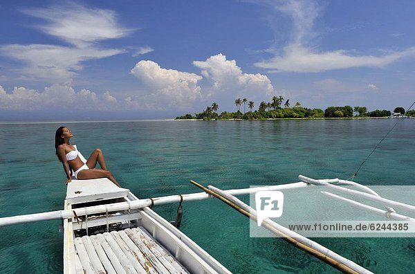 Girl on a traditional boat and the islet off the coast of Bohol  Philippines  Southeast Asia  Asia
