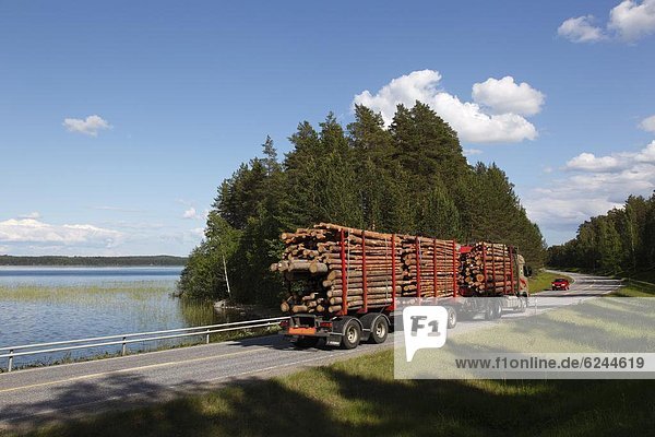 Truck transporting timber  Highway number 14  beside Lake Puruvesi  Punkaharju Nature Reserve  Saimaa Lake District  Savonia  Finland  Scandinavia  Europe