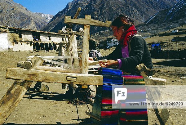 Woman operating carding machine  near MUKtinath  Nepal