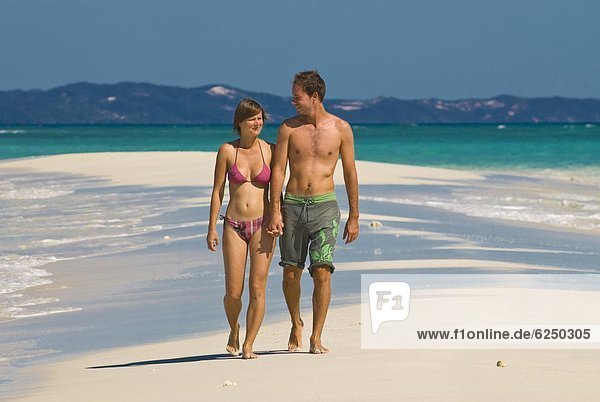 Happy couple on their honeymoon at the beautiful beach of Nosy Iranja near Nosy Be  Madagascar  Indian Ocean  Africa