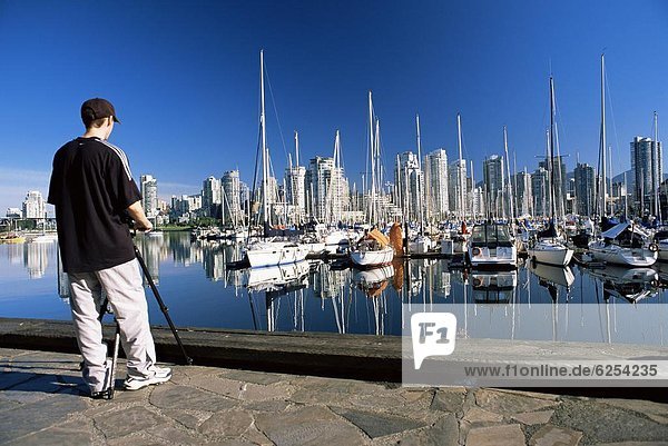 Photographer at False Creek marina  with downtown skyscrapers behind  Vancouver  British Columbia (B.C.)  Canada  North America