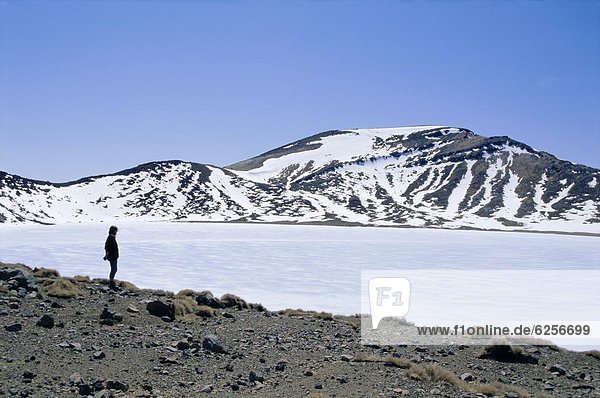 Hiker on Tongariro Crossing trek by Blue Lake under winter ice and snow  Tongariro National Park  UNESCO World Heritage Site  Taupo  South Auckland  North Island  New Zealand  Pacific