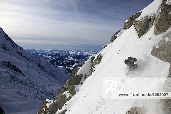 A snowboarder tackles a challenging off piste descent on Mont Blanc  Chamonix  Haute Savoie  French Alps  France  Europe