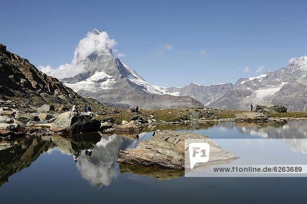 Hiker resting at Riffelsee and the Matterhorn behind  Zermatt  Valais  Swiss Alps  Switzerland  Europe