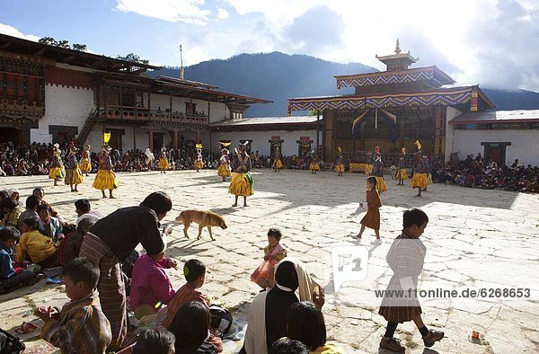 Masked dance in the main courtyard of the Gangte Goemba while local people and tourists watch during the Gangtey Tsechu  Gangte  Phobjikha Valley  Bhutan  Asia