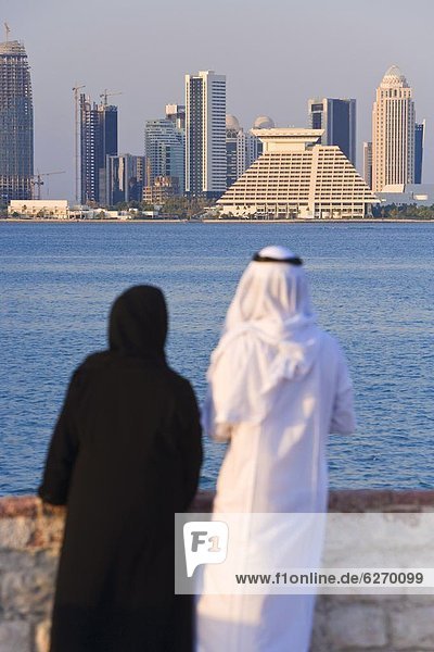 Skyline  Skylines  Frau  Mann  sehen  Großstadt  Naher Osten  Bucht  Ortsteil  Doha  Kleid  neu