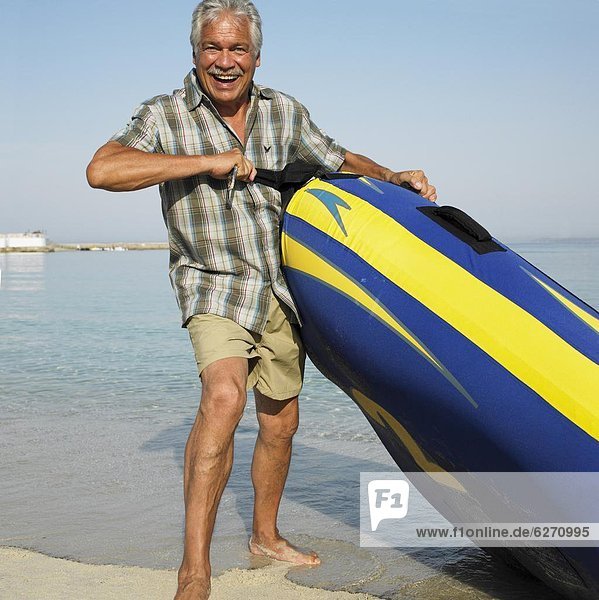 Senior  Senioren  Mann  Strand  aufblasen  Schlauchboot