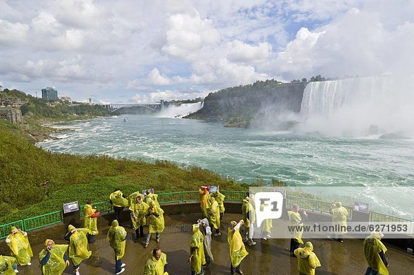 Many tourists in yellow raincoats in the spray of the Horseshoe Falls waterfall whilst on the Journey under the Falls tour  Niagara Falls  Ontario  Canada  North America