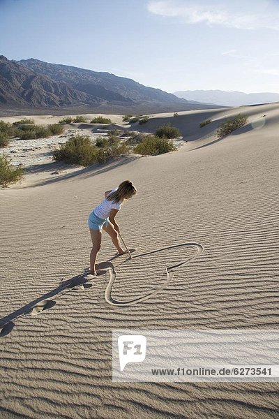 Woman drawing a heart in the sand  Sand Dunes Point  Death Valley 0tio0l Park  California  United States of America  North America