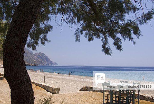 Europa  Strand  Meer  Kieselstein  in die Augen sehen  ansehen  Angesicht zu Angesicht  gegenüber  Tisch  Kreta  Griechenland  Taverne