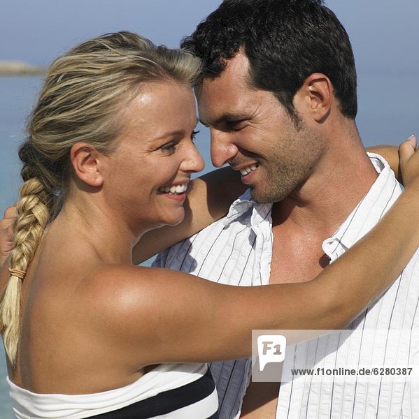 Couple embracing on beach  smiling