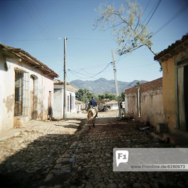 Street scene with man on horseback  Trinidad  Cuba  West Indies  Central America