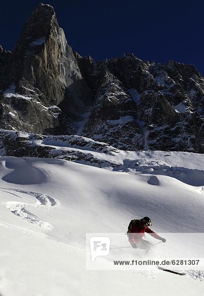 A skier enjoying perfect powder snow on the celebrated Pas de Chevre off-piste run  with the Dru in the background  Chamonix Valley  Chamonix  Haute Savoie  French Alps  France  Europe