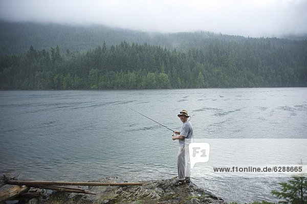 Man  30 years old  fishes on Ross Lake  North Cascades National Park  Washington  United States of America  North America