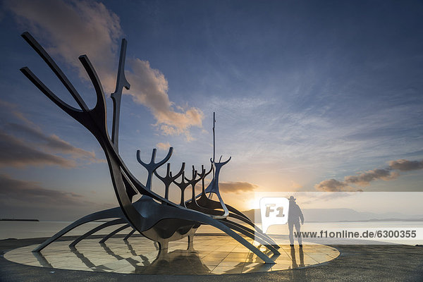 Man standing at the sculpture of a Viking ship  Sun Voyager or SÛlfar  Reykjavik  Iceland  Europe  PublicGround