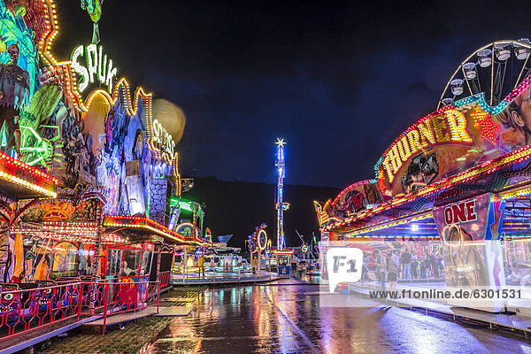 Ghost train  bumper cars and the No Limit XXL funfair ride at night after a heavy shower  Suedring amusement park  Innsbruck  Tyrol  Austria  Europe