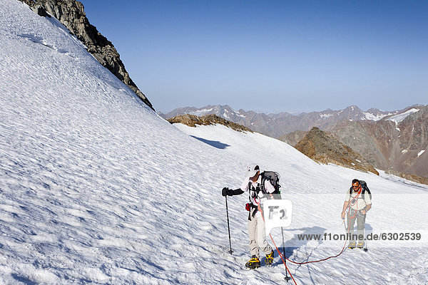 Hikers during the ascent to the peak of Similaun mountain  on Niederjochferner glacier in the Schnalstal valley above the Fernagt reservoir  Grosser Kahndl mountain at the back  province of Bolzano-Bozen  Italy  Europe