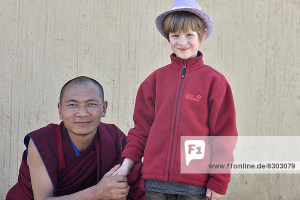 Monk holding the hand of a European child  6 years  Labrang Monastery  Xiahe  Gansu  formerly Amdo  Tibet  China  Asia