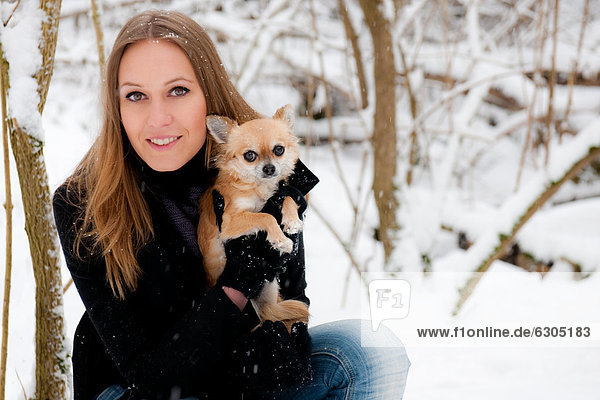 Young woman with dog in snow  portrait