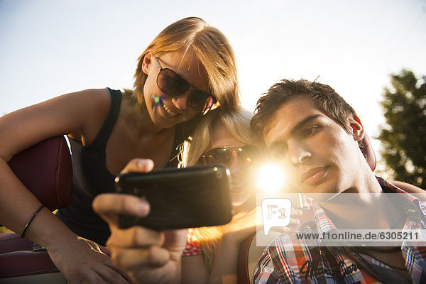 Drei Freunde gucken ein Video auf einem Handy