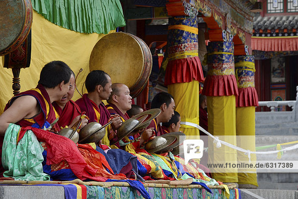 'Tibetan Buddhism  monk orchestra  monks with instruments at the religious masked dance ''Cham'' festival in the important Gelupgpa monastery of Kumbum  Ta'er Monastery  Huangzhong  Xinning  Qinghai  formerly Amdo  Tibet  China  Asia'