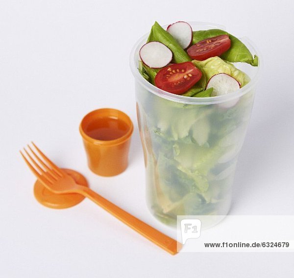 Salat mit Dressing und Plastikgabel zum Mitnehmen