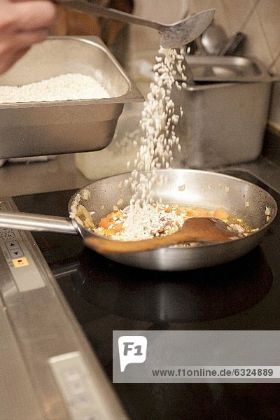 Paella zubereiten: Reis zufügen