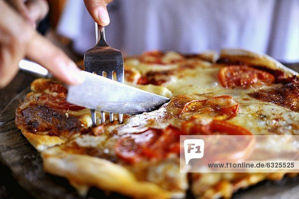 Pizza in Stücke schneiden