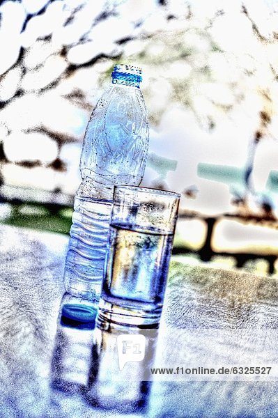 Wasserflasche und Wasserglas auf Tisch