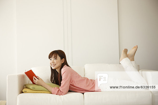 Japanese Woman Lying Down And Holding Book