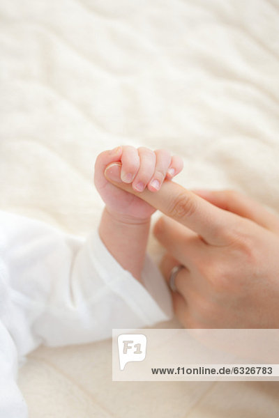 Baby hält Mutter Finger