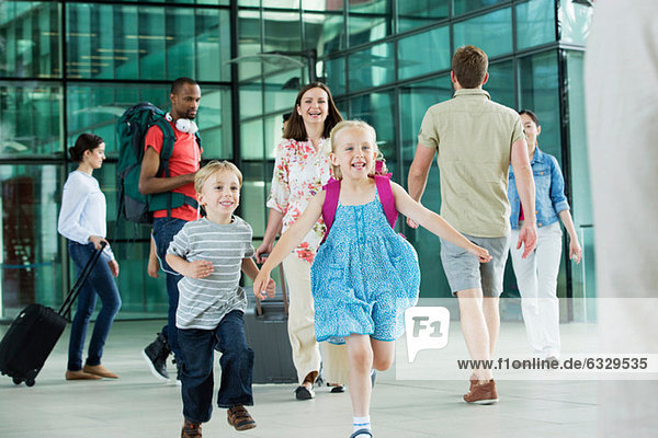 Aufgeregte Kinder beim Laufen auf dem Flughafengelände