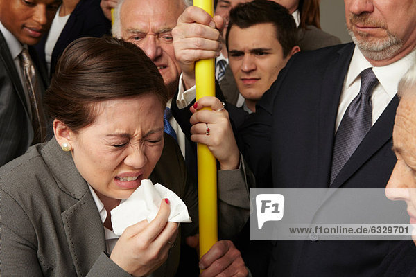 Businesswoman sneezing on subway train