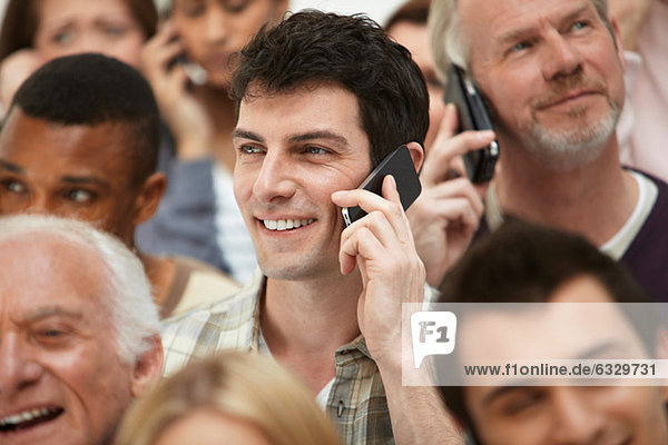Man on cell phone with group of people