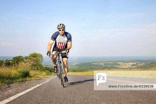 Man cycling on open road