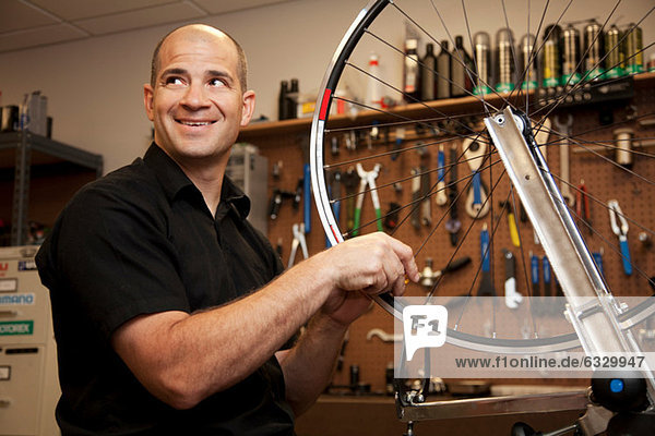 Man fixing bicycle rim in workshop